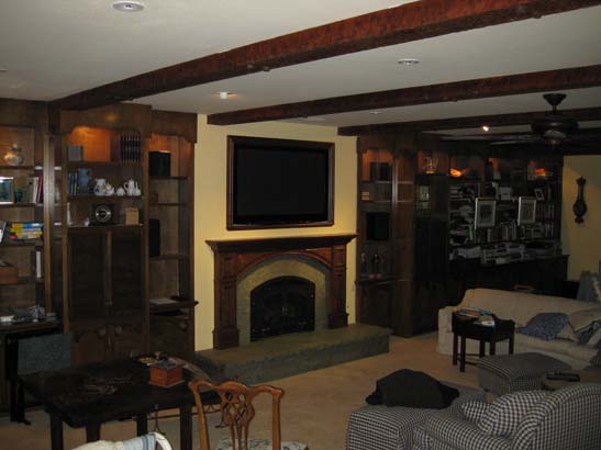 After photo of a cherrywood paneled gas fireplace with green marbel mantel.